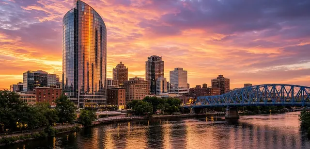 Downtown Grand Rapids at sunset, with the Blue Bridge crossing the Grand River in the foreground.
